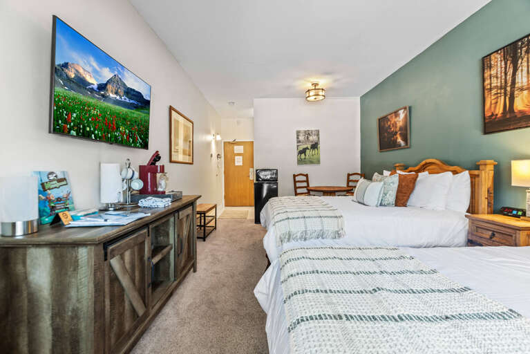 Step into your mountain-inspired retreat, where two cozy beds and warm wood furnishings create the perfect space to unwind after a day of exploring.