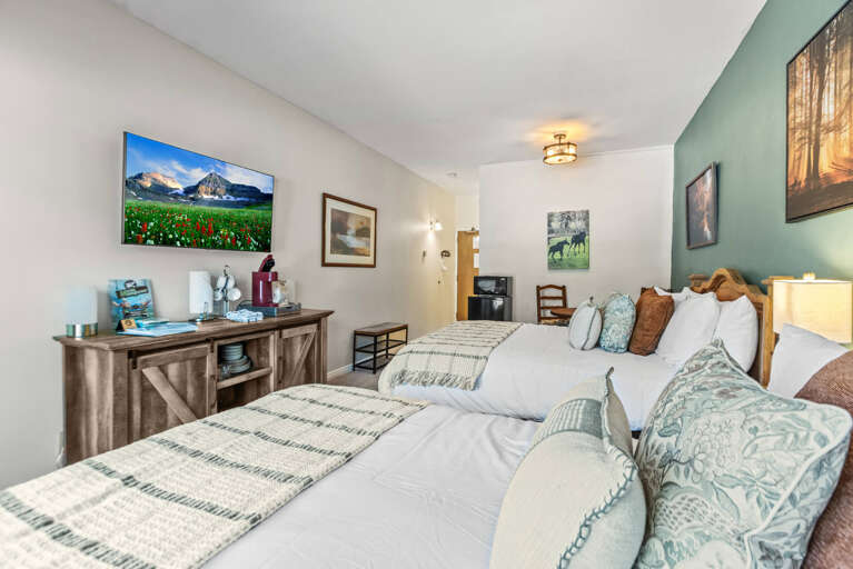 Sink into plush bedding with calming sage accents, unwind in your thoughtfully designed bedroom. Enjoy comfortable amenities, cozy lighting, and a restful retreat after a day of adventure.