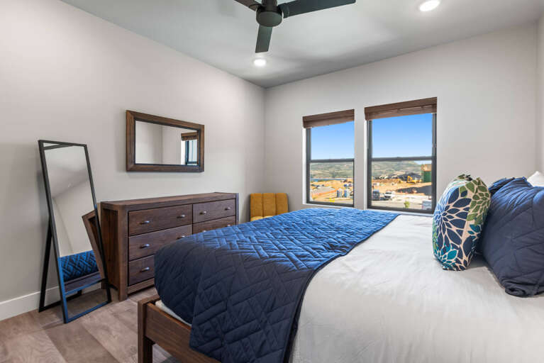 Rest easy in your cozy bedroom, where rich wood furnishings and a plush bed welcome you at day's end. Wake up to sweeping neighborhood views through bright windows that fill the space with warm natural light.