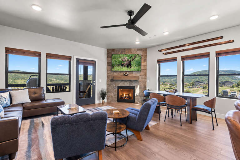Relax in your spacious living room with a cozy fireplace and sweeping desert views through expansive windows. The open design invites you to unwind by the fire or enjoy meals at the elegant dining table.