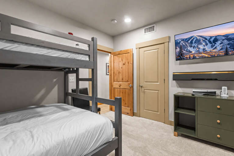 Your cozy bunk room offers comfortable sleeping for family or friends, with modern gray bunks, warm wood accents, and convenient storage to keep your belongings organized during your stay.