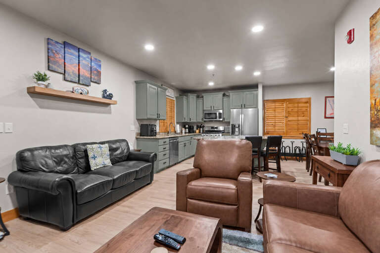 Settle into your spacious open-concept living area, where leather seating invites relaxation and a fully equipped kitchen stands ready for home-cooked meals and morning coffee.