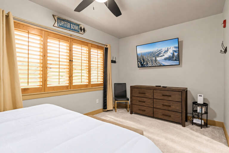 Unwind in your comfortable bedroom with a cozy bed, plenty of storage, and natural light filtering through plantation shutters. The ceiling fan keeps the air fresh while you relax and recharge.