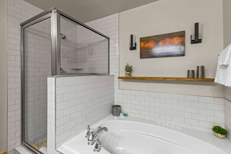 Step into your spa-like bathroom featuring a pristine walk-in shower with sleek glass enclosure and a relaxing soaking tub, all accented by warm wood shelving and soft lighting.