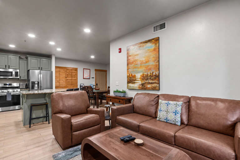 Unwind in your spacious open-concept living area, featuring plush leather seating and a fully equipped kitchen. The warm, modern design makes it easy to gather, cook, and relax as one.