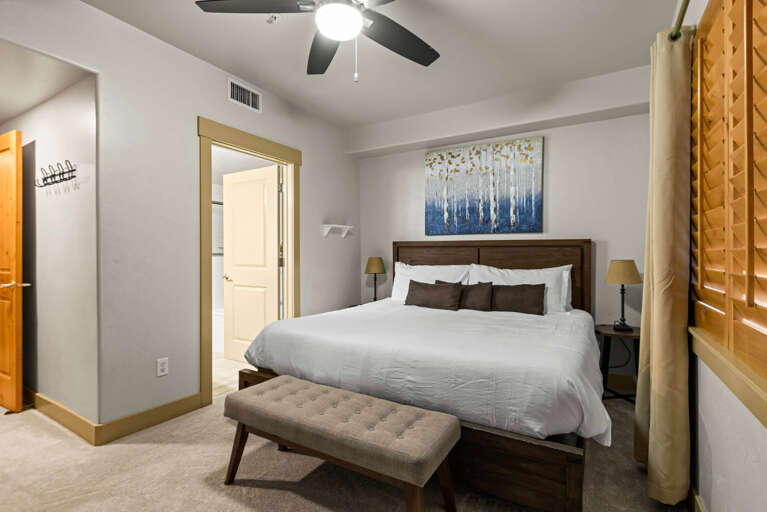 Sink into crisp linens and let the ceiling fan's gentle breeze ease you into relaxation. Your peaceful retreat awaits with elegant wood furnishings and thoughtful touches to make you feel at home.
