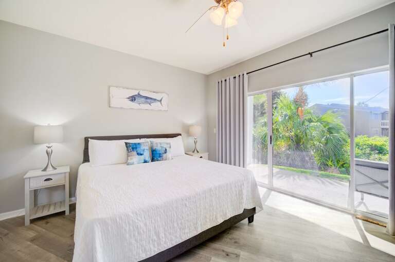Bright Bedroom With White Bed, Sliding Glass Doors, And Scenic View