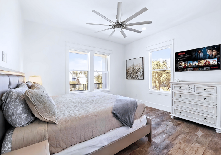 2nd floor coastal Bedroom #3 with a king bed has a mounted flat-screen TV.