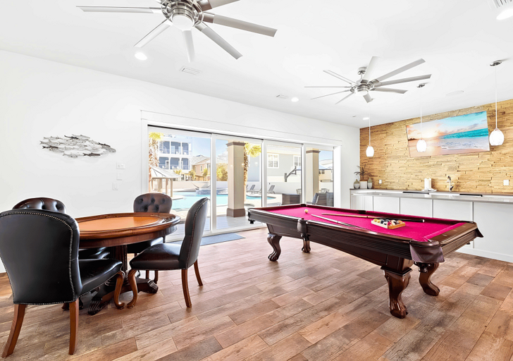 The game room is equipped with a billiard and poker table for family fun