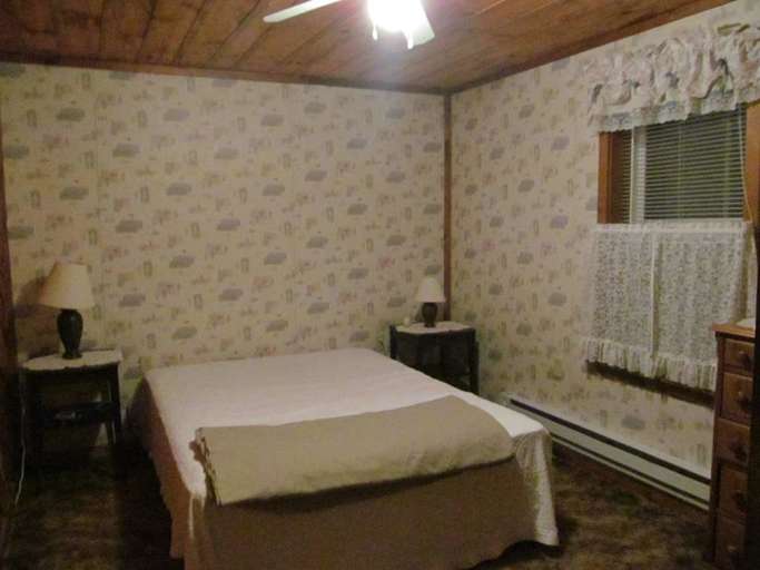 Dimly Lit Bedroom With Patterned Wallpaper And Simple Furnishings Dimly Lit Bedroom With Patterned Wallpaper And Simple Furnishings