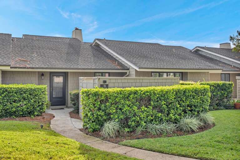 Single-story Structure Surrounded By Lush Shrubs And Manicured Lawn