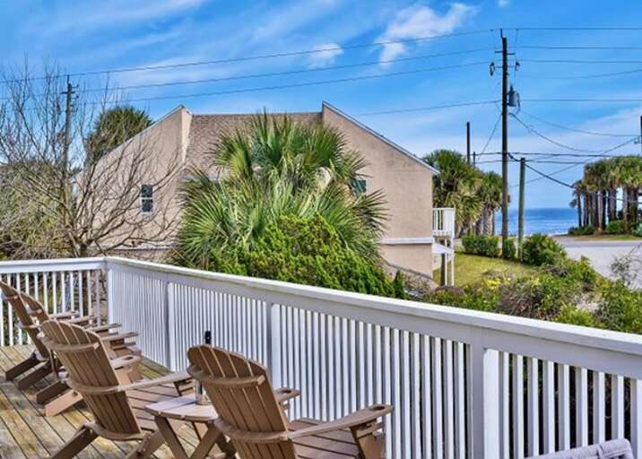 Beachfront House With Wooden Chairs On Balcony
