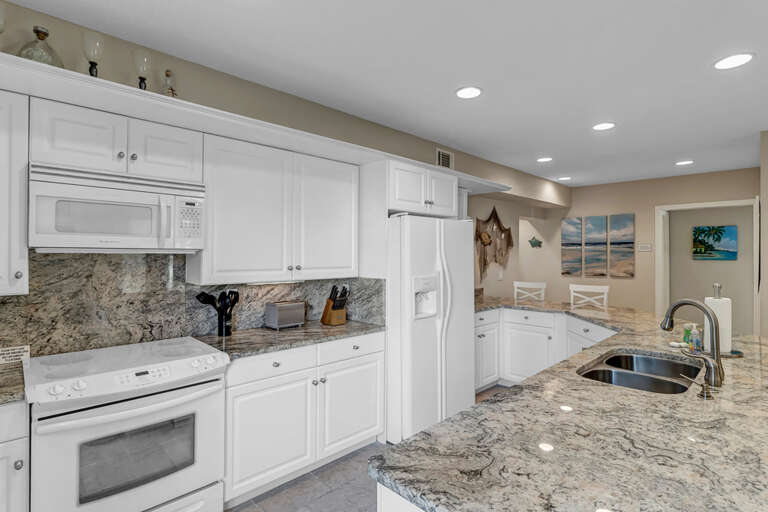 Bright Residential Kitchen Interior With White Cabinets And Appliances