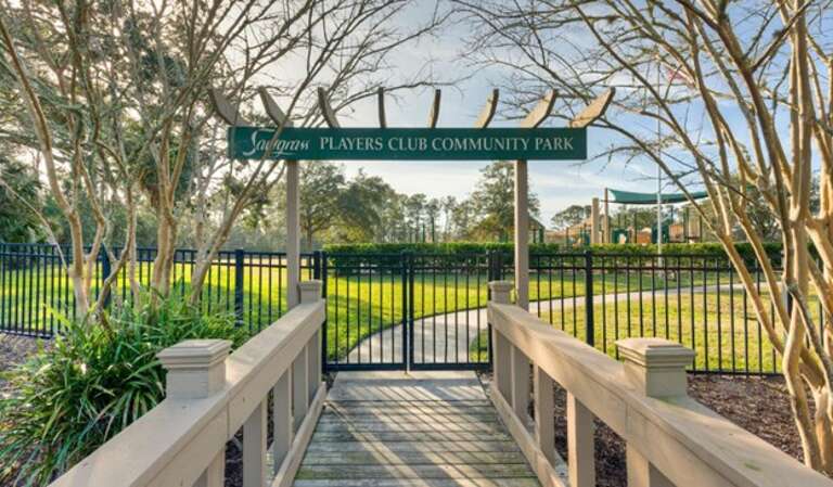Wooden Walkway Leading To Lush Park