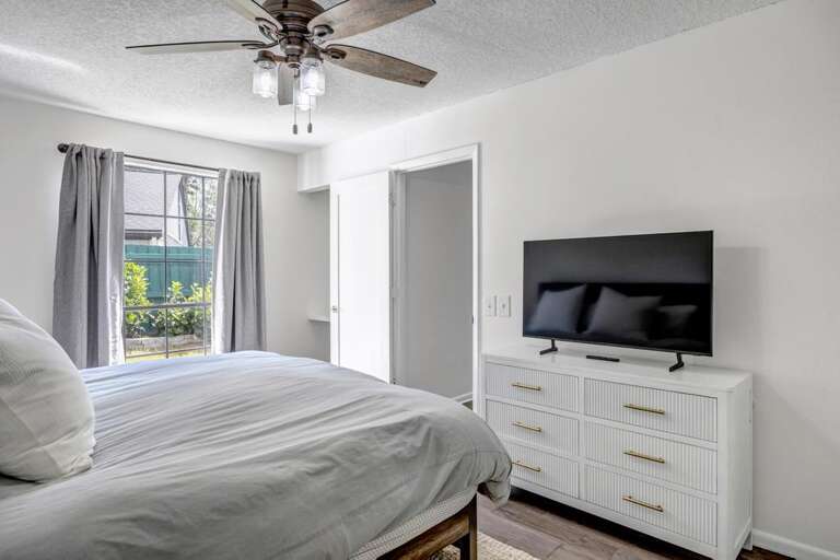 Bright Bedroom, Big Bed, Window With View, White Walls, Ceiling Fan, Television On Dresser