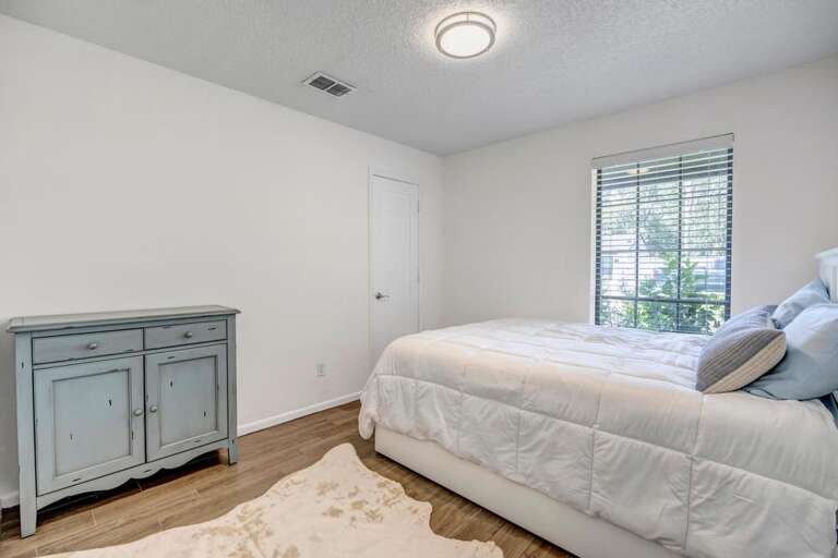 Simple Bedroom Setup With Basic Bed, Small Cabinet, And Subtle Lighting