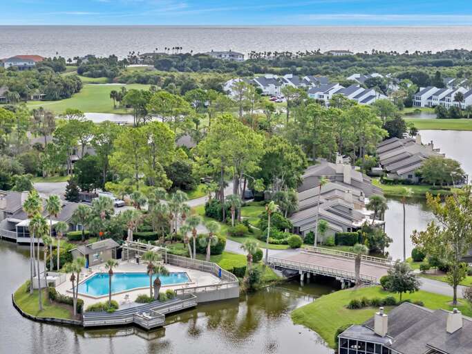 Aerial View Of Residential Complex With Pool Beside Blue Bay