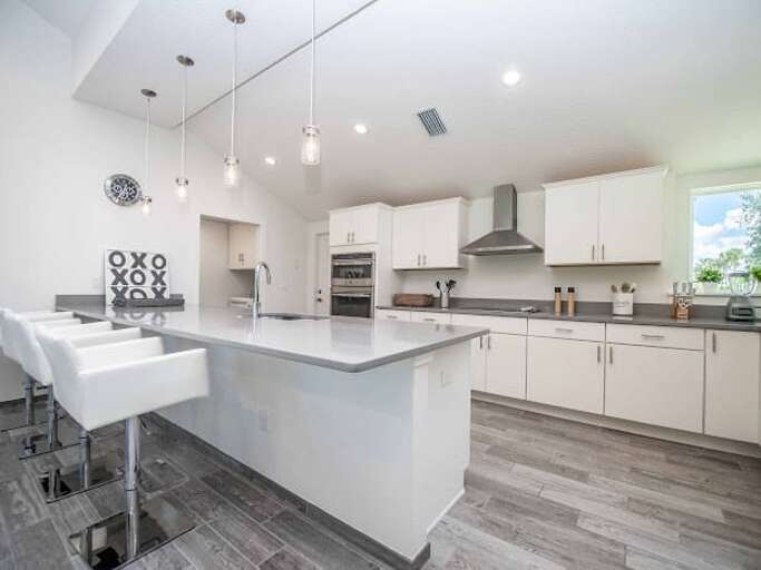 Minimalist Kitchen With Clean Countertops, Pale Palette, Pendant Lighting