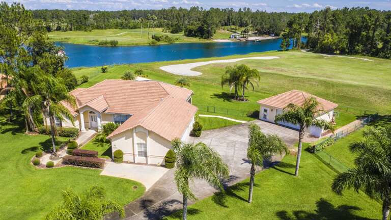 Aerial View Of A Lakeside Vacation Rental, Surrounded By Green Grounds And A Golf Course