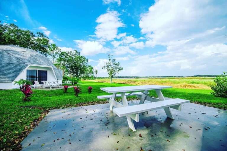 Dome Dwelling By Verdant Vista, White Bench Beneath Blue Skies