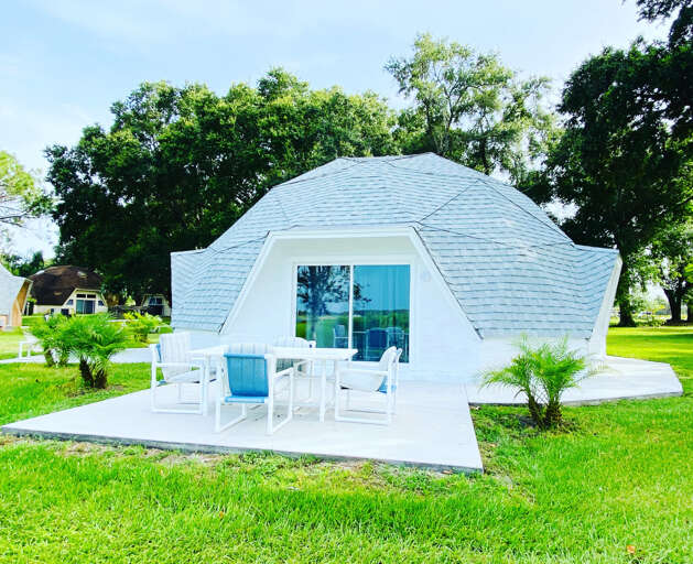 Dome-shaped Dwelling In Daylight With Deck And Chairs On Grass