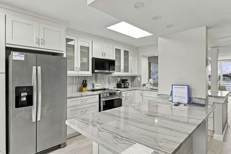Spacious kitchen with full-size refrigerator and breakfast bar seating.jpg