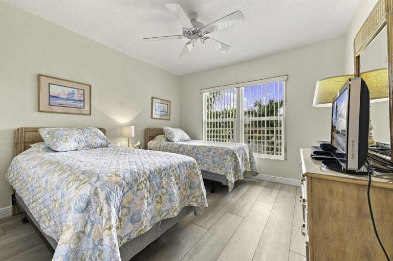 Comfortable guest bedroom with two beds and plenty of natural light.jpg