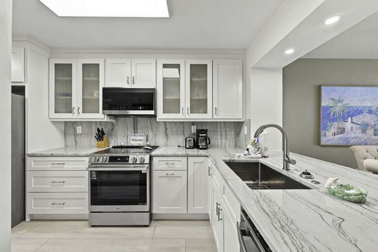Updated kitchen with white cabinetry and modern appliances.jpg