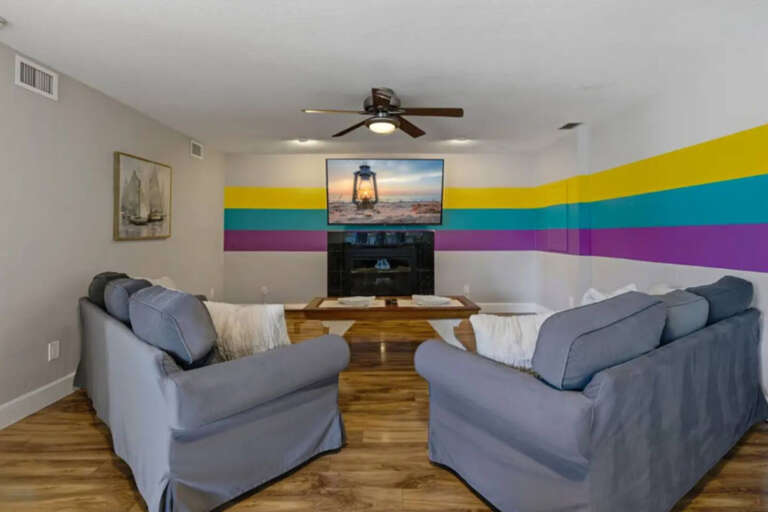 Living Room With Striped Wall And Sofas Facing A Fireplace