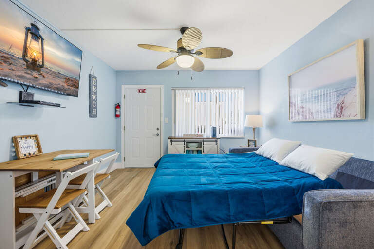 Comfortable sleeper sofa provides additional sleeping space in this bright coastal living area, perfect for a relaxing beach vacation.