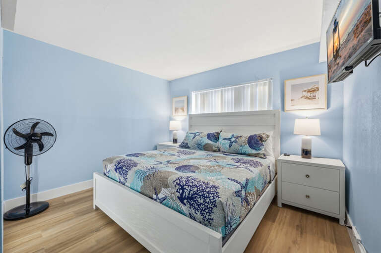 Relaxing coastal bedroom with comfortable bed, Smart TV, bedside lighting, and beach-inspired décor for your Florida Gulf Coast stay.