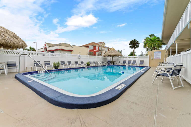 Pool Inviting outdoor pool with lounge chairs and shaded tiki seating, perfect for relaxing and enjoying the Florida sunshine.