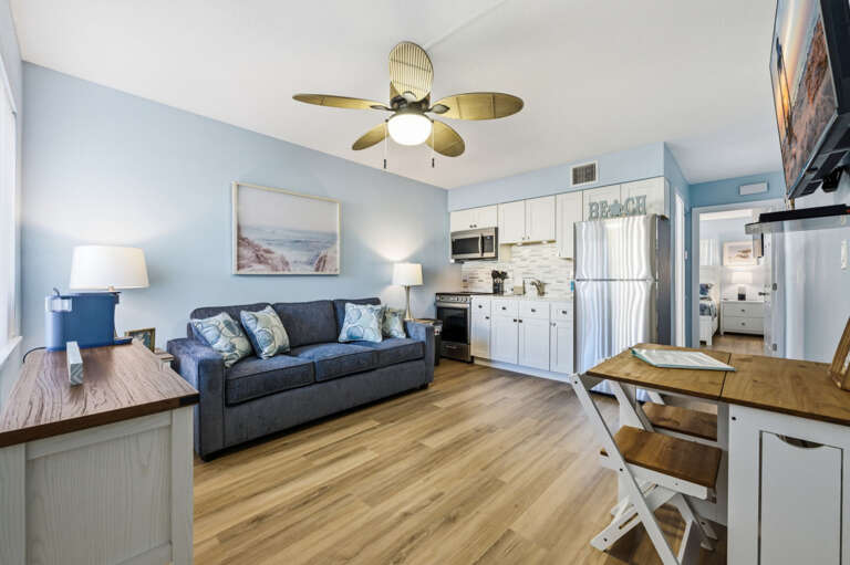 Open-concept living room and fully equipped kitchen with coastal décor, comfortable seating, and everything needed for an easy beach getaway.