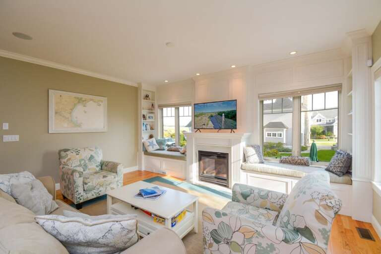 Light-filled Living Room With Plush Seating, Polished Floors, And Picturesque Windows In A Serene Vacation Rental