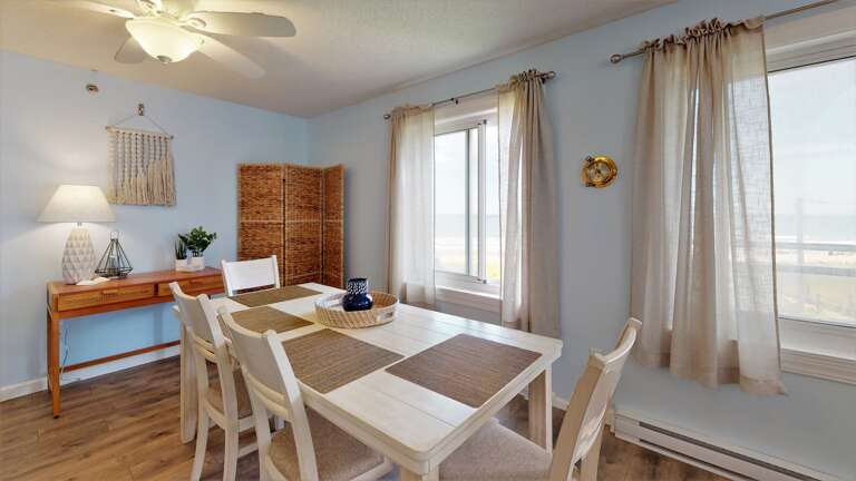 Bright, Breezy Room With White Table And Chairs, Light Streaming Through Sheer Curtains