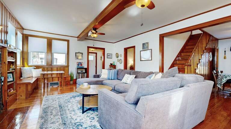 Spacious Living Area With Stairs, Wooden Floors, And Soft Sofa