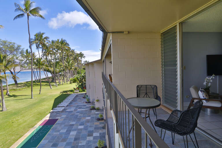 Recently upgraded tile patio on property with shuffleboard and lounge chairs