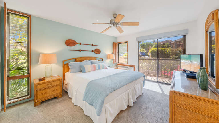 Relax in this comfortable bedroom with lush tropical landscaping surrounding