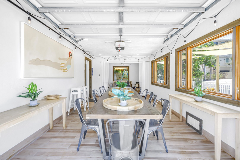 Dining area with large windows, modern tables, and seating.
