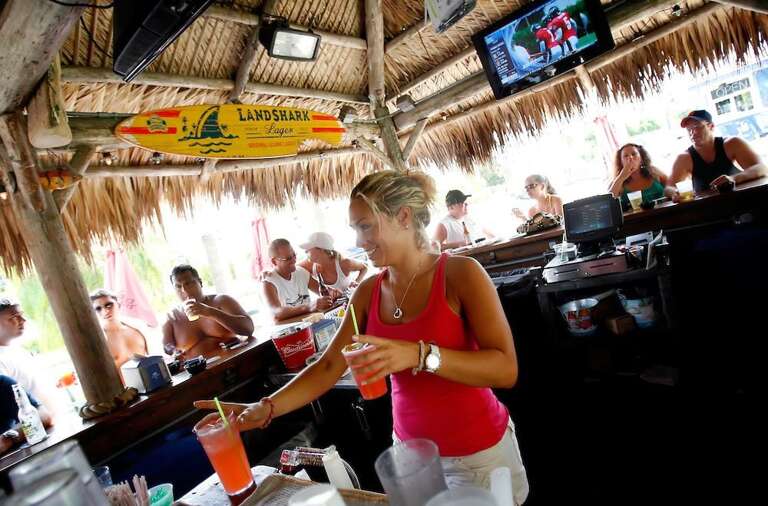 Beach Bar With People And Thatched Roof