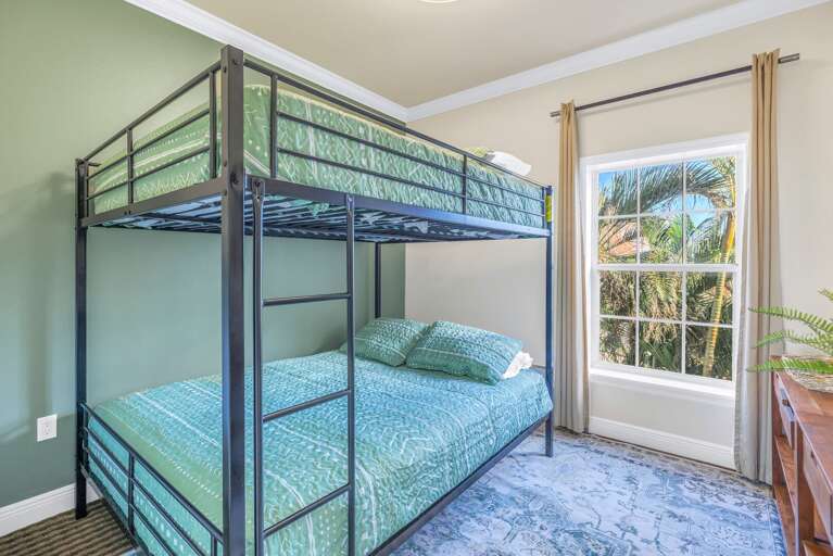 Breezy Bedroom With A Bunk Bed, Blue Rug, And Bright Window View Of Greenery Breezy Bedroom With A Bunk Bed, Blue Rug, And Bright Window View Of Greenery