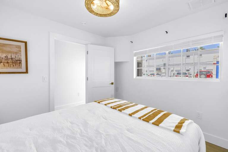 Bright bedroom with comfortable bedding and sunny window views. A peaceful retreat in the heart of Siesta Key Village.
