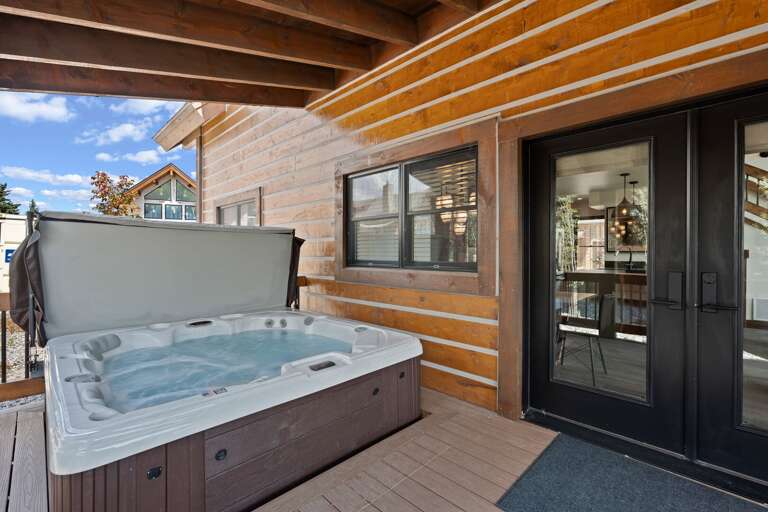 Outdoor patio with hot tub and fireplace