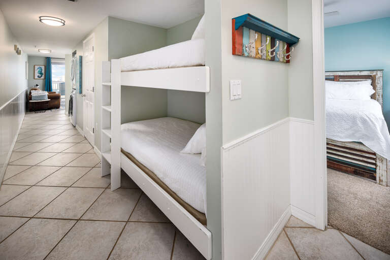 Twin size bunk beds and washer/dryer in the hallway