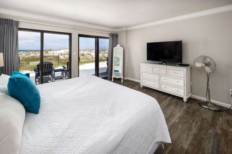 Master bedroom with TV and slider doors to the back porch