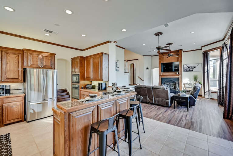 View of kitchen and bar with main living area behind