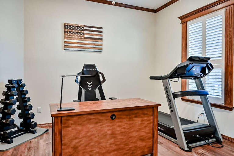 Study with executive desk, tradmill, weight set, yoga/pilates mat and TV.