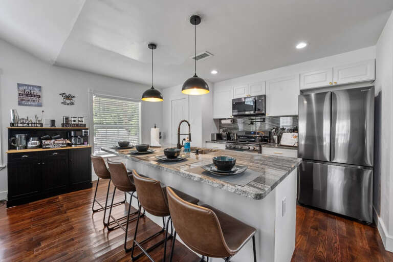 Full Kitchen and bar seating area with view of cocktail bar