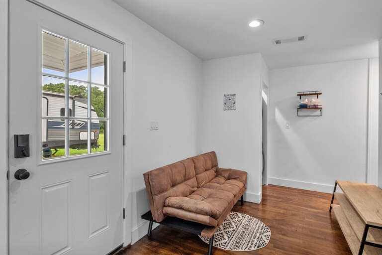 Entryway from front driveway with workspace area and futton that folds if desire to sleep on full size futton and view to laundry area