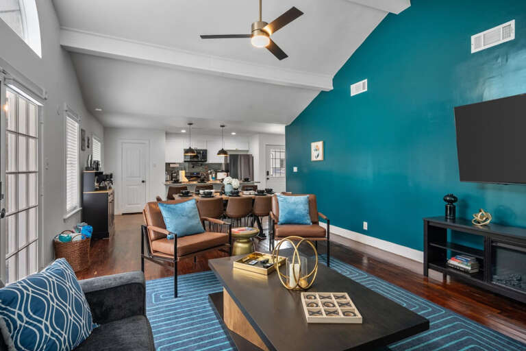 Living Room with view to kitchen and dining.  Couch and chair sitting area with Smart TV